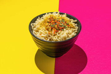 Colorful Bowl of Noodles on Vibrant Pink and Yellow Background