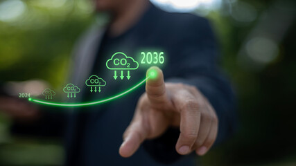 A man is pointing at a graph that shows the year 2036 and the CO2 emissions