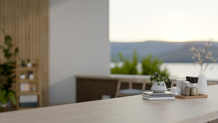 A wooden table featuring books, a decorative plant, and a coffee set in a contemporary room.