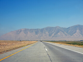 Driving to Oquirrh Mountain range by US route 80 highway on sunny day