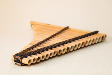 Male hands holding a rondador on a beige isolated background. Andean instrument, pan flute, traditional South American instrument.