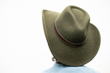 Mestizo male model with curly hair wearing blue shirt and wool cowboy hat with leather decoration. Portrait with blurred natural background and contemporary Andean cultural style.