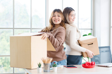 Portrait two roommates happy young Asian female moving packing things in box into new apartment, carry cardboard boxes, Concept teenage or friends, Real estate property buying, relocation, new home