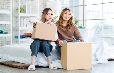 Portrait two roommates happy young Asian female moving packing things in box into new apartment, carry cardboard boxes, Concept teenage or friends, Real estate property buying, relocation, new home