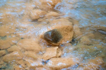 Water flows over the rusty brown rocks at The Silica Rapids