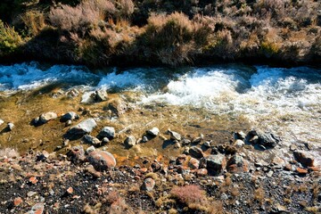 Water flows over the rusty brown rocks at The Silica Rapids