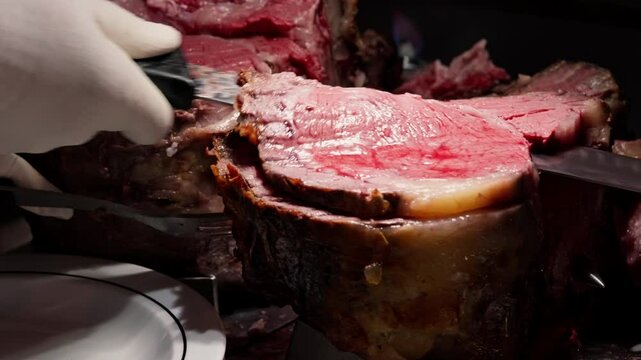 A chef slices thick roast beef and places it on a hot plate, showcasing the tender, juicy interior and rich, seared exterior. The close-up emphasizes the savory aroma and sizzling presentation.