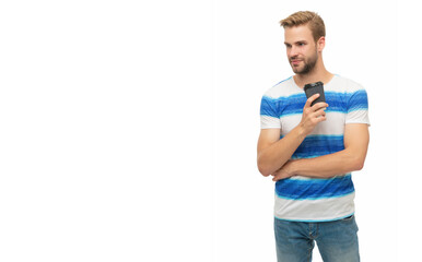 Fototapeta premium Young man in casual t-shirt holding paper cup of coffee. Drink hot tea isolated on white. Man relaxing with coffee. Takeaway coffee cup. Millennial man enjoying cup of coffee. Copy space banner