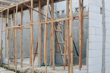 A construction site with a ladder leaning against a wall.