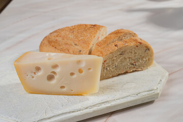 White bread and hard cheese with holes lie on a light background