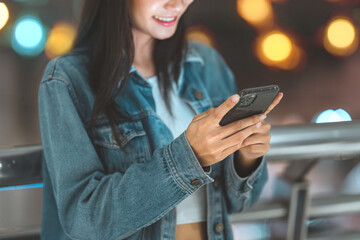 Closeup hands of happy woman using smartphone at night on city, female hands texting on smartphone late in evening. online internet.