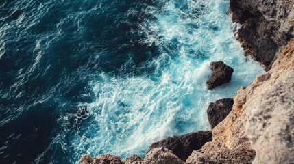 A stunning cliffside view of the ocean with waves crashing against the rocks, offering space for text above. Perfect for coastal, travel, or adventure themes.
