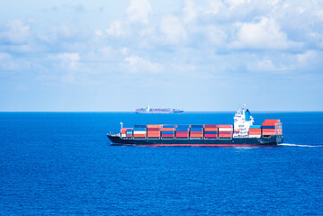 Cargo container ship sailing through calm, blue Indian Ocean. She is beginning voyage on her international trade route.