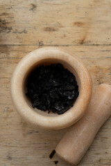 Black powder with marble mortar on light background