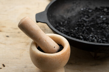 Black powder with marble mortar on light background