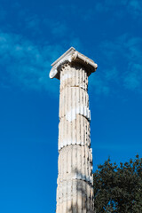 Solitary ancient Greek column stands against blue sky. Lone Column Against the Sky