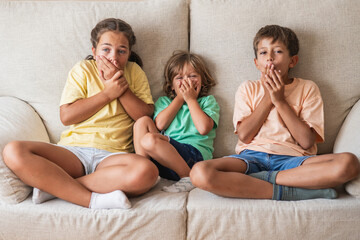 Three Children Watch TV At Home With Playful Enthusiasm. Their Positive Emotions And Joyful Energy...