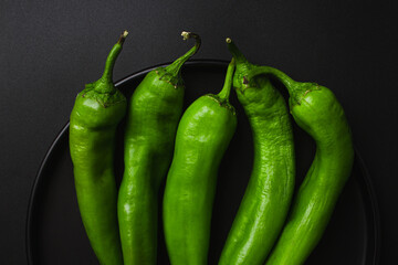 Green chili pepper on black background