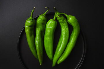 Green chili pepper on black background