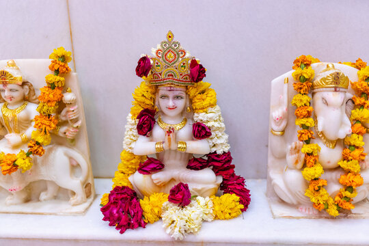 Idol of goddess parvati decorated with rose and marigold flower at temple.