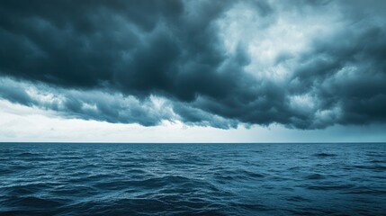 Fototapeta premium Dark storm clouds rolling over the ocean, with ample space for copy.