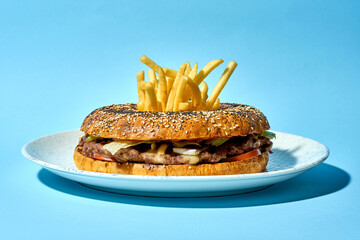 burger served on sesame bagel. The burger is topped with of crispy French fries, creating a unique...