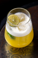 Satsuma cocktail in glass on dark background