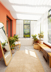 Frontal view of a large bathtub in a covered veranda with white curtains. Bright, calm and relaxing. Nobody inside.