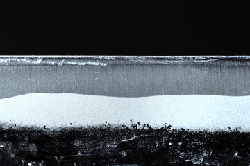 日本の伝統鍛冶打刃物・青銅の刃先と刃境、縞筋模様を水平に撮影した青光り黒背景画像素材。