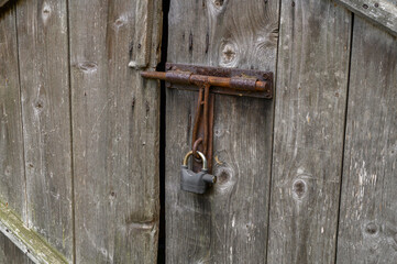 Stara zardzewiała kłódka zabezpieczająca wejście do wiejskiego budynku gospodarczego, korozją stara konstrukcja © Paweł Kacperek
