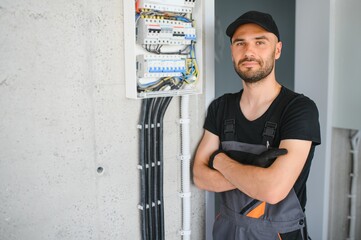 Male electrician working in a switchboard with fuses