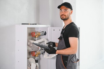 The worker installs or inspects Fire extinguisher and fire hose reel in building corridor