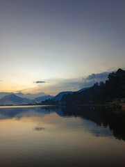 Fototapeta premium reflection of the evening sunset on a beautiful lake background with a blue orange sky