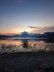 Fototapeta premium reflection of the evening sunset on a beautiful lake background with a blue orange sky