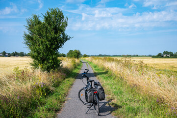 Fototapeta premium Trekking bike with paniers standing at a lonely countryroad for cyclists in Rodby, Denmark