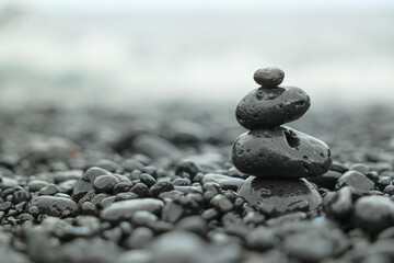 Balanced stones on a misty pebbled beach