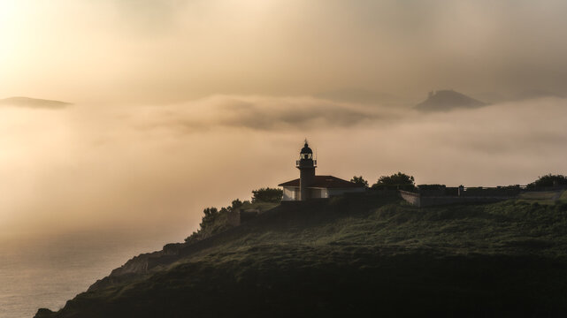 Misty Lighthouse at Coastal Sunset