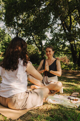 Mentor and student before Mindful meditation and yoga in an open area. Deep relaxation and inner contemplation of people. Facilitating meditative experience. Part of the series.