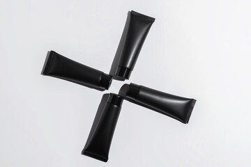 Black cosmetic tubes on a clean white background