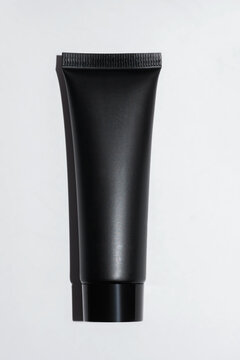 Black cosmetic tube with matte finish on white background
