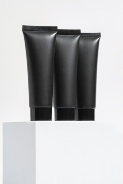 Trio of Black Cosmetic Tubes on White Background