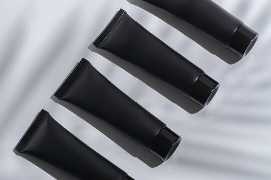 Elegant Black Cosmetic Tubes Floating on White
