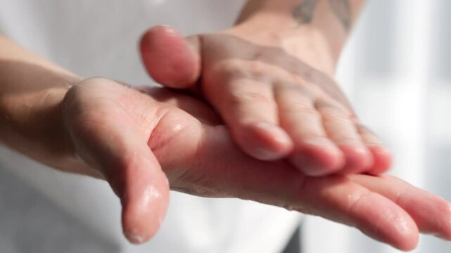A man moisturizes his hands with thick cream.
Hand care.
Man's hands.
Skin problems.
Dry hands.
Body balm