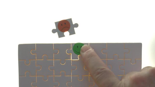 Puzzle with a green smiley face assembled and a red sad face piece unplaced, representing emotional choices and decision-making