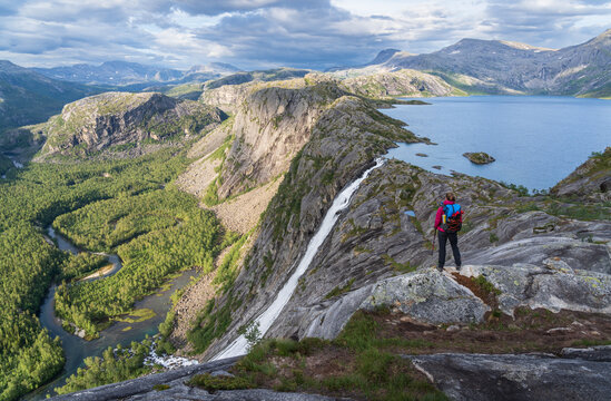 Hiker looking at the waterfall in National Park Rago, Norway.