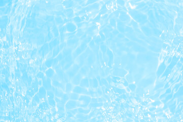 Blue water with ripples on the surface. Defocus blurred transparent blue colored clear calm water surface texture with splashes and bubbles. Water waves with shining pattern texture background.