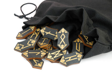 Close up of black runes with sack isolated on white background. Fortune telling concept.