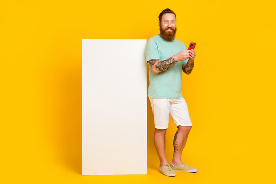 Full body cadre of youngster wear green t-shirt hold phone browsing interface new apple device ios device screen isolated on yellow color background