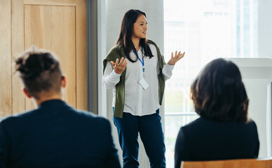 Professional woman speaking at a business workshop to colleagues