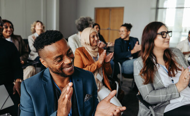 Multiethnic coworkers applauding and smiling at a workshop